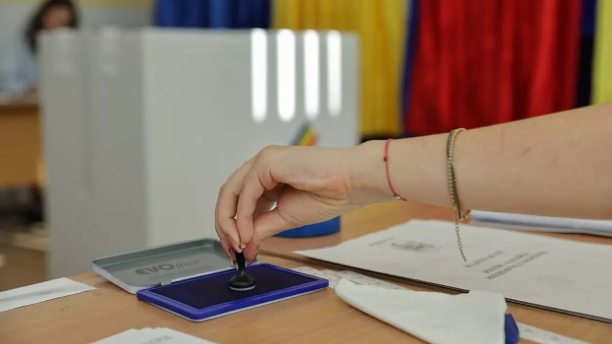 O femeie ia ștampila din tușieră pentru a pune pe buletinul de vot, la alegerile prezidențiale din România, București, 4 mai 2025