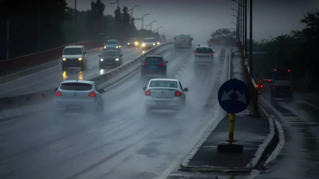 Mașinile din București mergând pe drumul aglomerat într-o zi ploioasă și întunecată de primăvară.