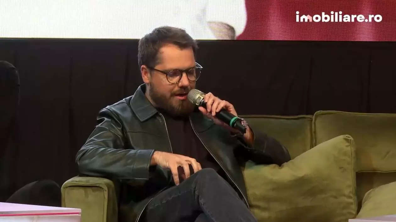 Gaspar Gyorgy, îmbrăcat într-o geacă de piele neagră, cu blugi negri, pe canapea, la conferința Imobiliare.ro HUB Național 2025
