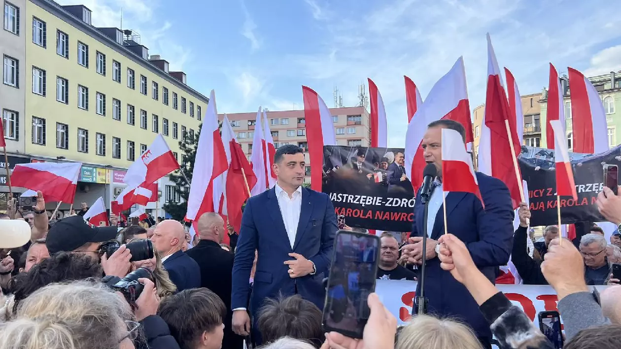 George Simion alături de candidatul suveranist la alegerile prezidențiale din Polonia, pe o scenă, înconjurați de oamnei și de steaguri ale Poloniei