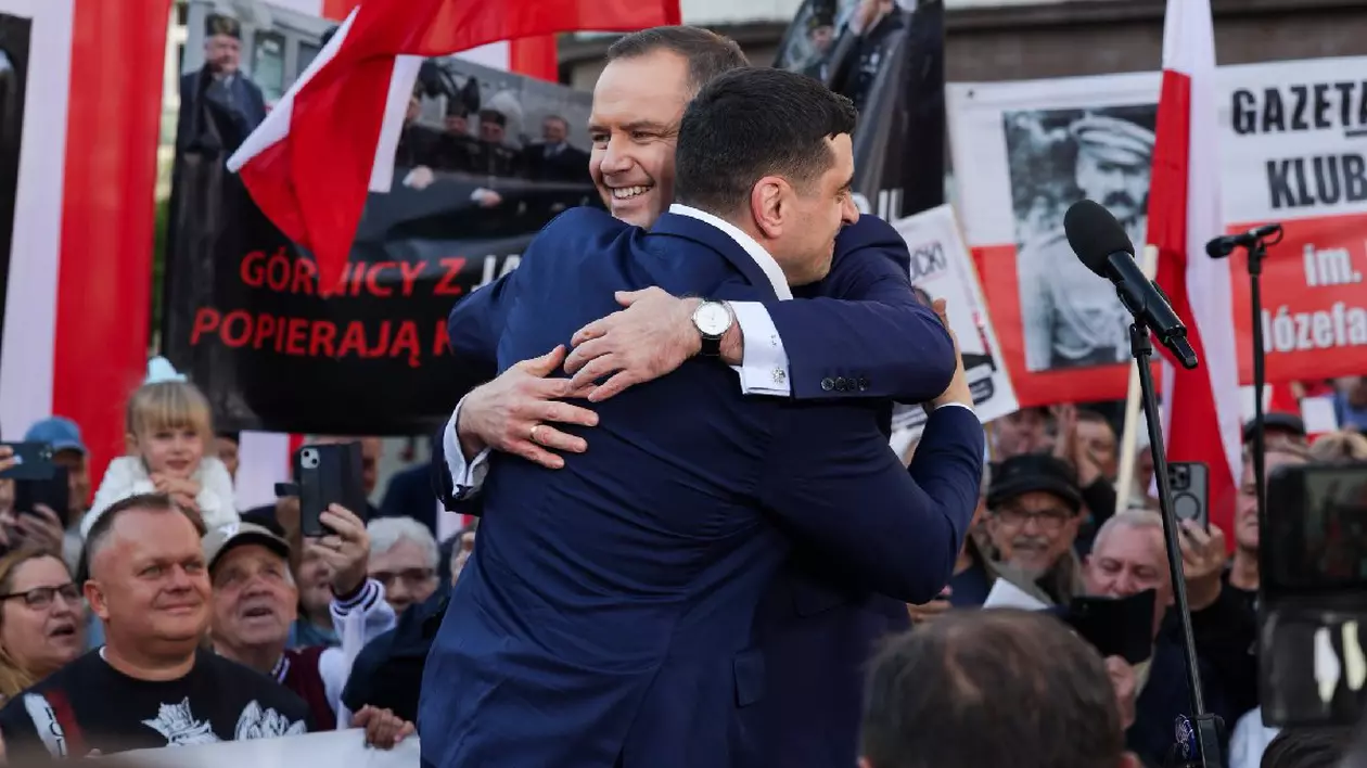 George Simion alături de candidatul suveranist la alegerile prezidențiale din Polonia, pe o scenă, înconjurați de oamnei și de steaguri ale Poloniei