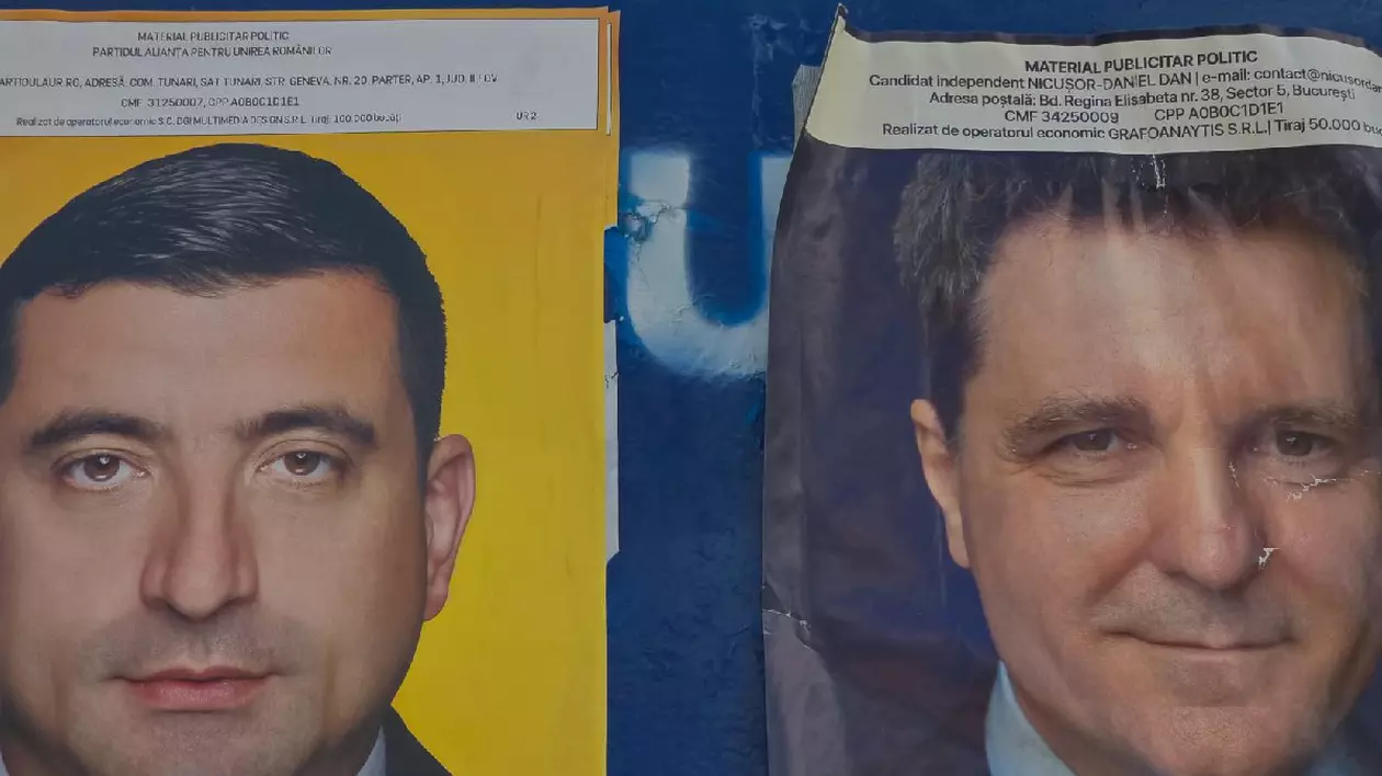 Două afișe cu George Simion și Nicușor Dan, pe un panou electoral albastru, înainte de turul 2 al alegerilor prezidențiale din România