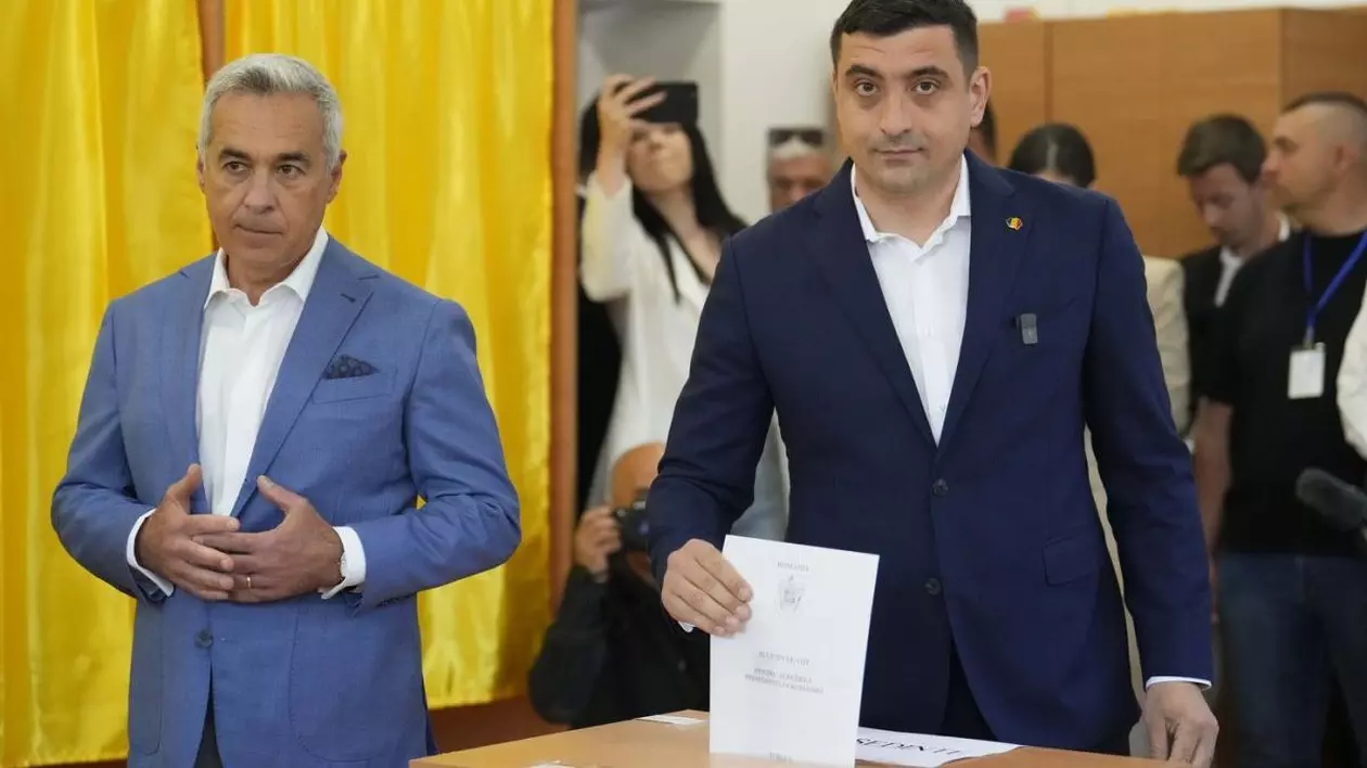 Candidatul AUR la prezidențiale George Simion (dreapta) introduce în urnă buletinul de vot și se află lângă Călin Georgescu, câștigătorul primului tur al alegerilor anulate de anul trecut, Mogoșoaia, duminică, 4 mai 2025.