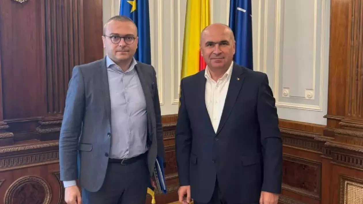 Iancu Guda și Ilie Bolojan, în spatele lor se văd 3 steaguri.