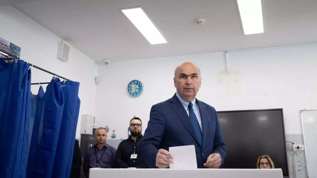 Ilie Bolojan ține într-o mână buletinul de vot pentru alegerile prezidențiale 2025. A fost fotografiat înainte de a-l introduce în urnă