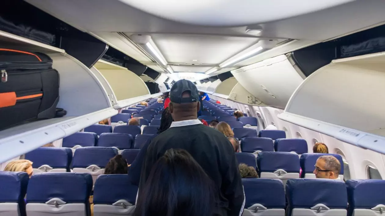 Pasageri in avion mergand spre locurile lor inainte de decolare