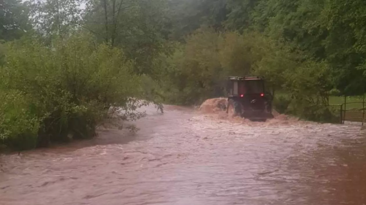 Un tractor a fost luat de viitură pe un râu din România care a ieșit din matcă.
