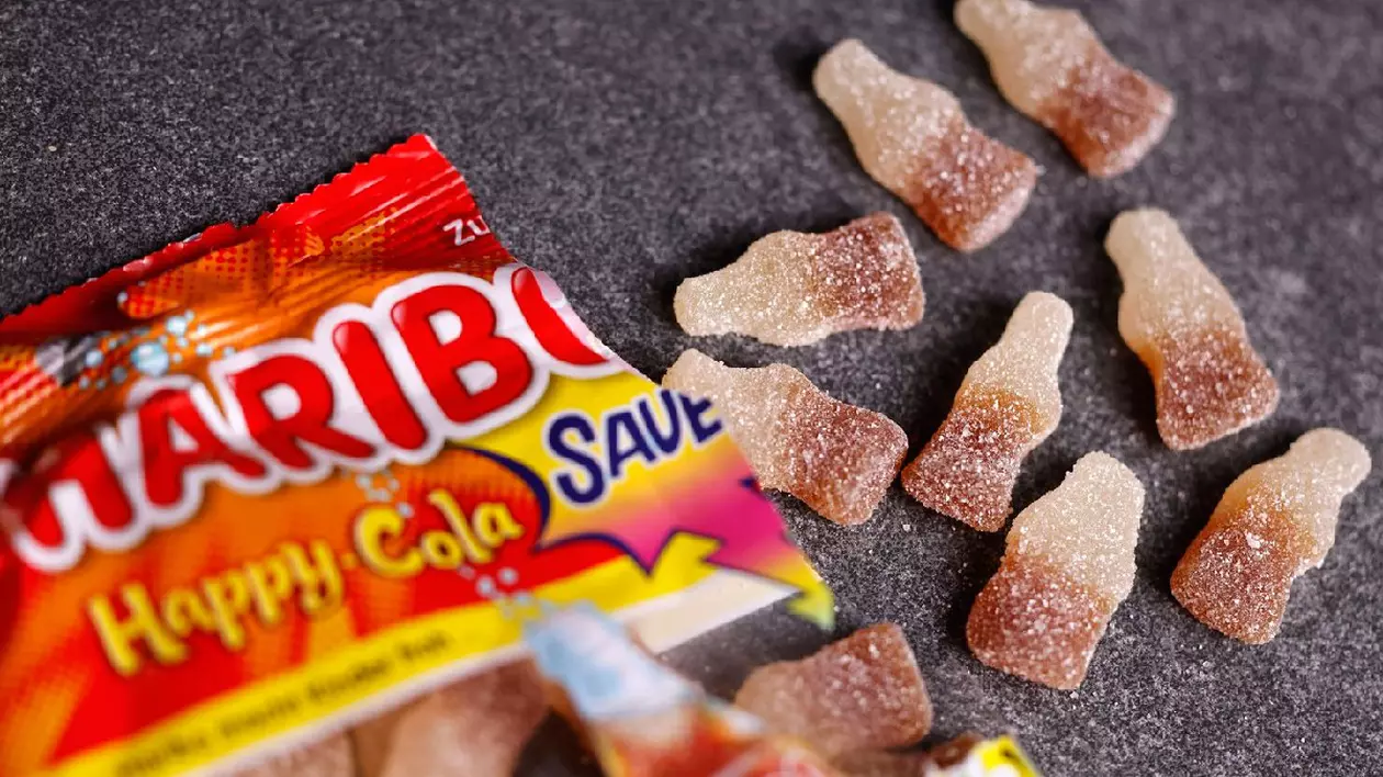 Jeleuri Haribo se află pe o masă. Haribo Happy Cola sour este un produs gumat cu gust acrisor