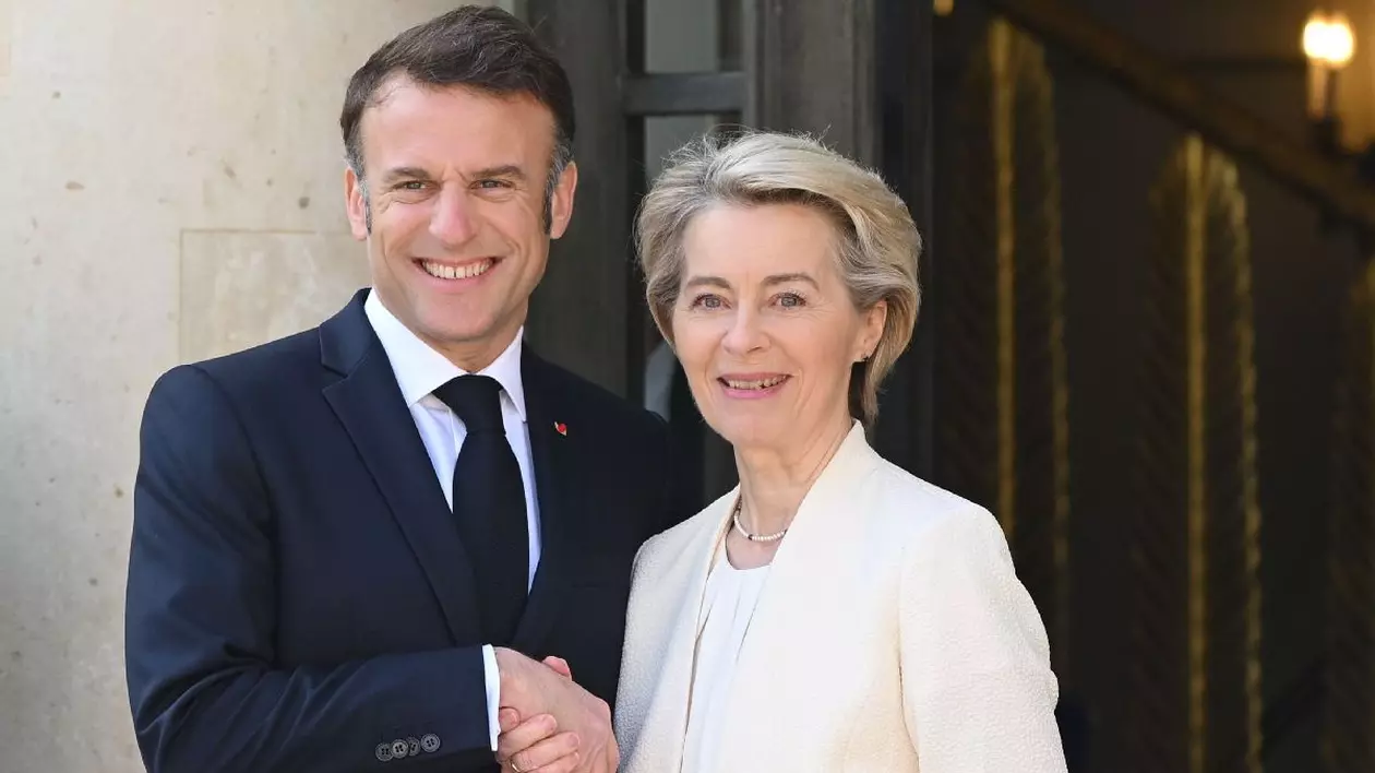 Emmanuel Macron și Ursula von der Leyen se țin de mână și zâmbesc entuziasmați
