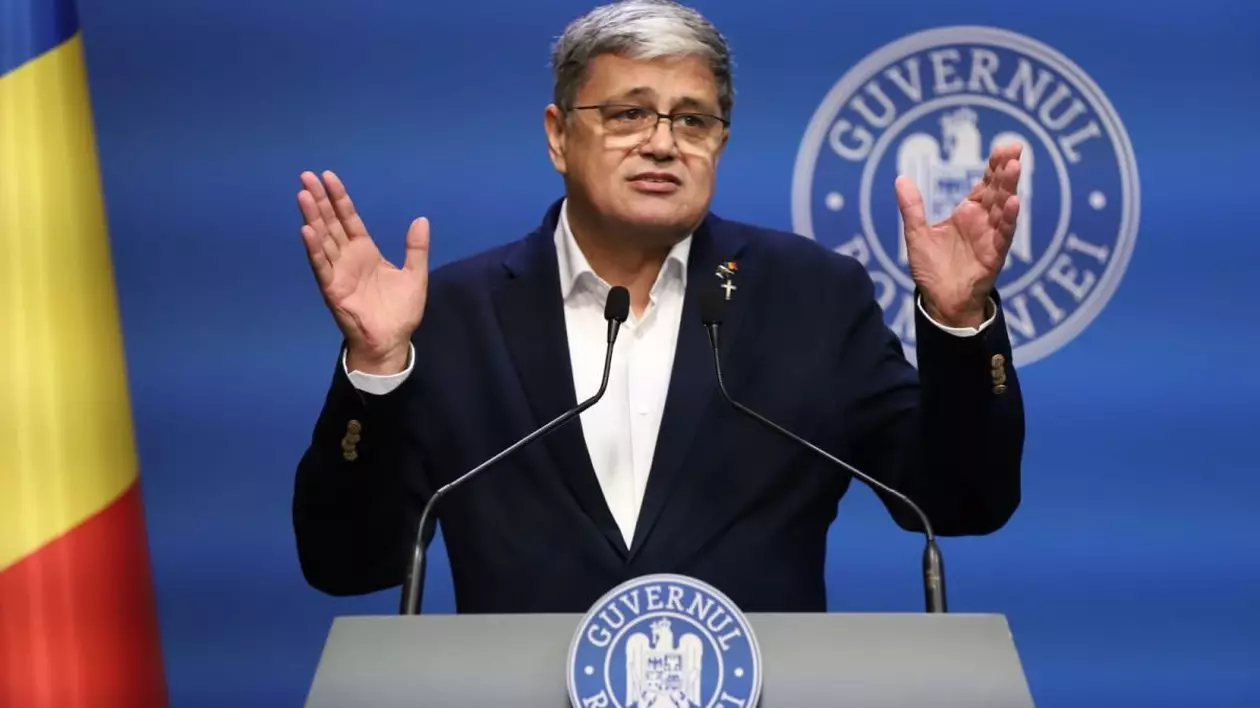 Ministrul Proiectelor Europene, Marcel Boloș, surprins când gesticulează din mâini și vorbește la microfon de la pupitrul Guvernului, la o conferință de presă, vineri, 30 mai 2025