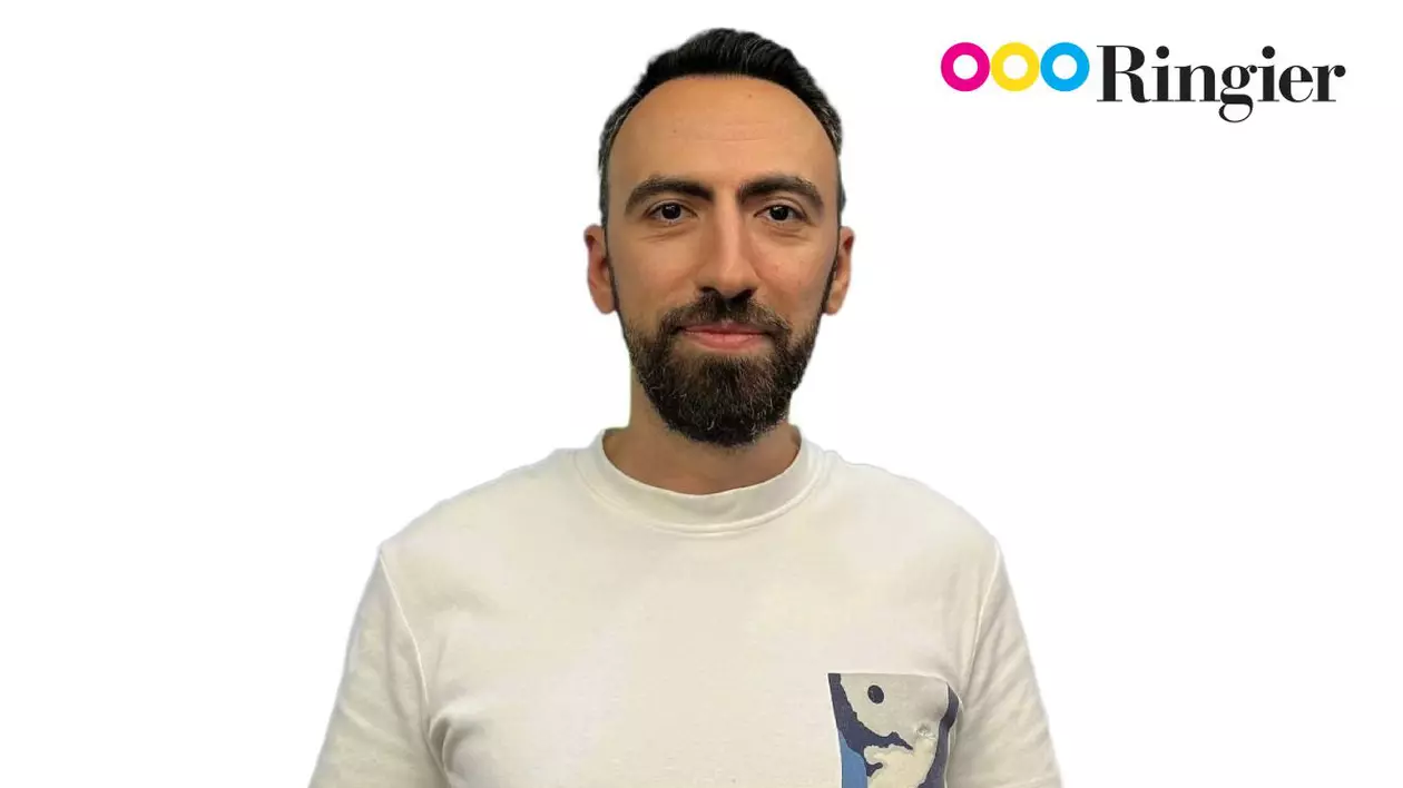 Mihai Badea, îmbrăcat cu un tricou alb, pe fundal alb, cu logo-ul Ringier în dreapta-sus