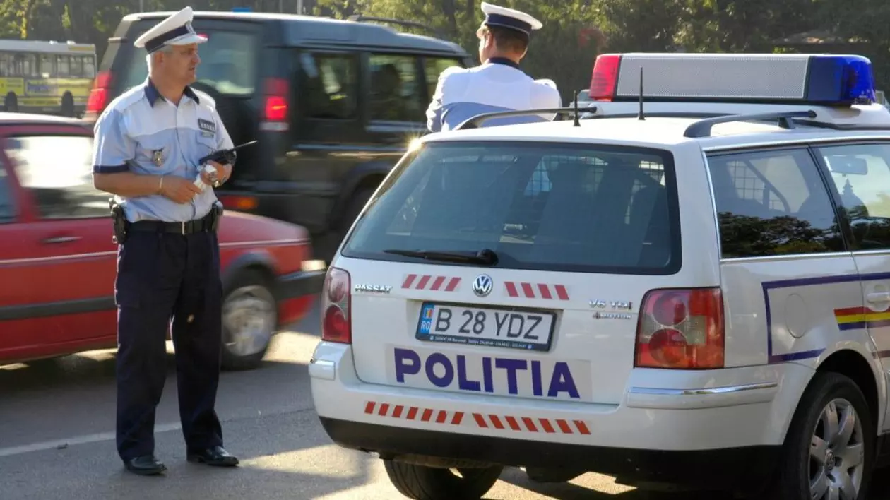 Polițisti pe stradă în București, vara, masini pe strada si o masină de poliție in prim-plan