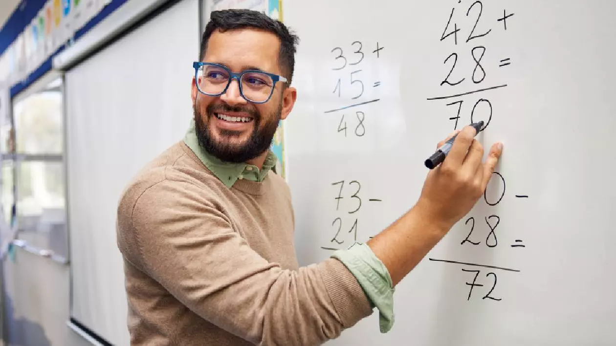 profesor de matematică face calcule pe tablă în clasă