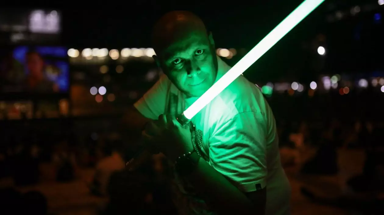 Un bărbat mânuiește o sabie laser în timp ce urmărea filmul Star Wars