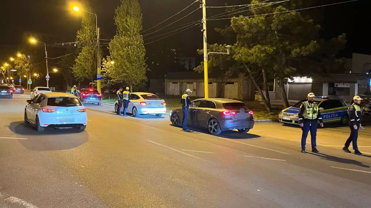 Mașini în trafic, în Mamaia, în noaptea de 1 spre 2 mai 2025, cu o mașină de poliție și doi polițiști în uniformă aflați pe marginea drumului