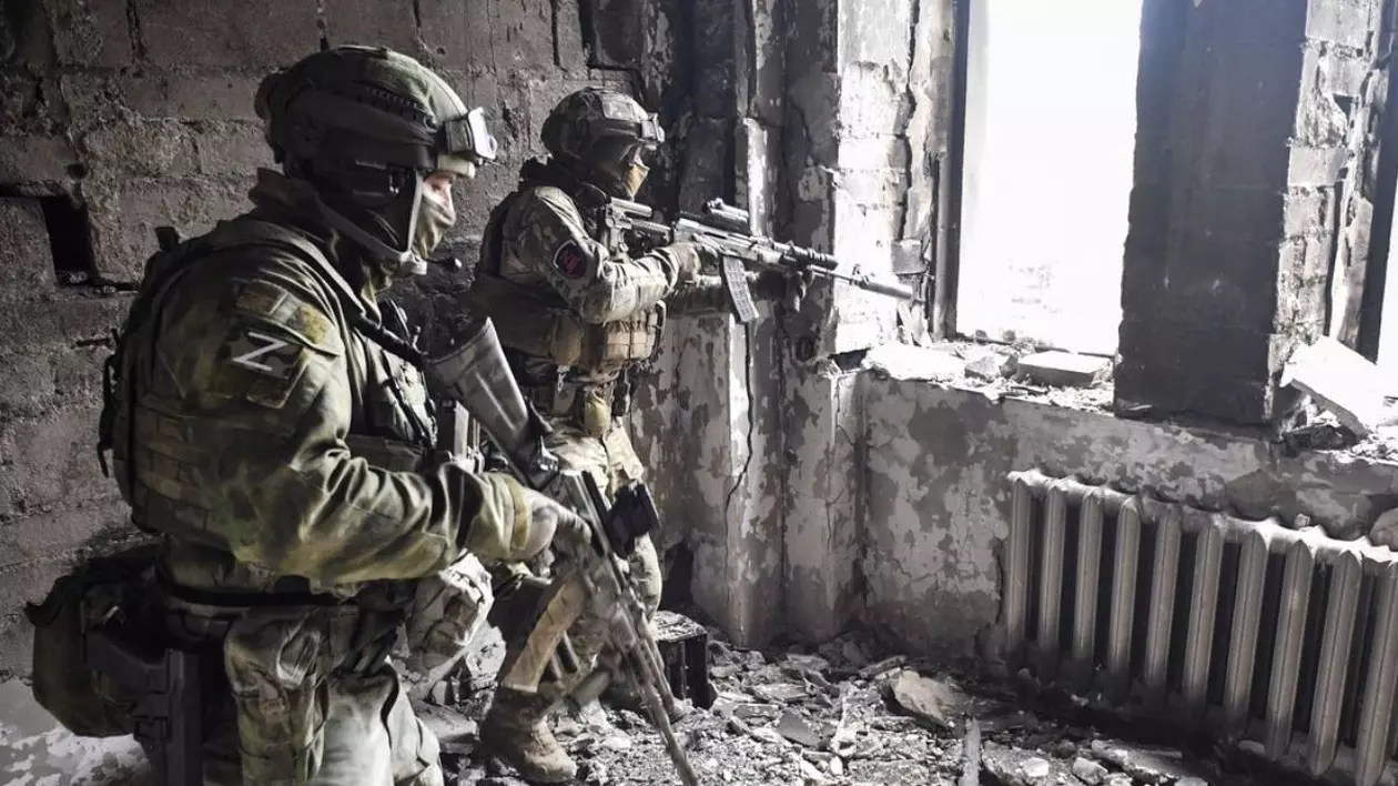 În imagine doi soldați rusi în mijlocul unor ruine din Mariupol, Ucraina