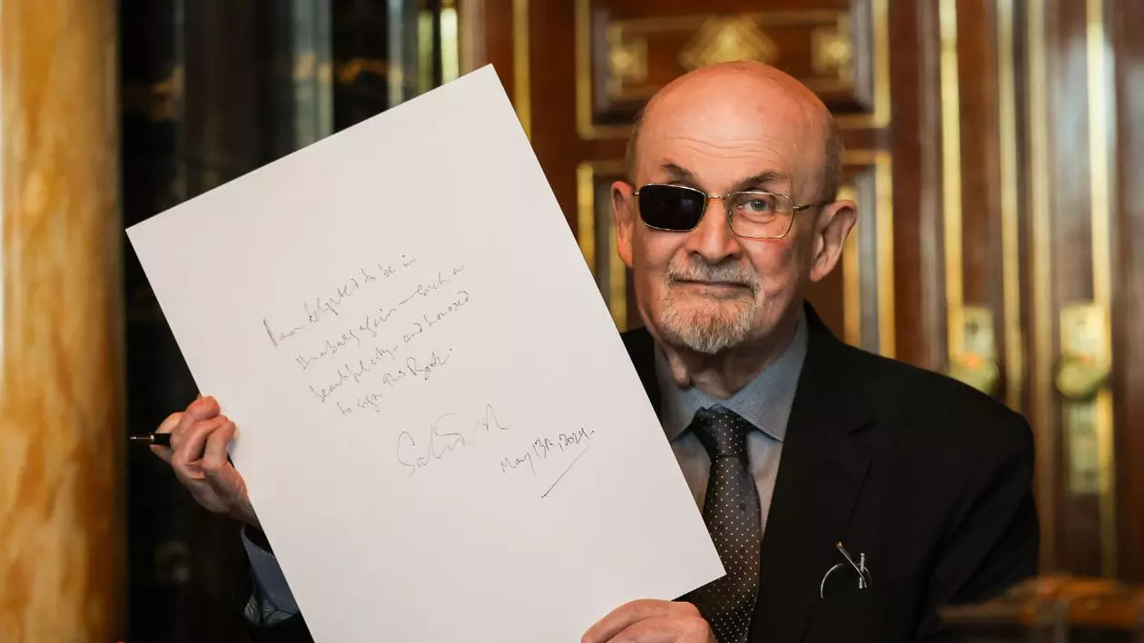 Scriitorul indiano-britanic Salman Rushdie arată textul său după ce a semnat în Cartea de Aur a orașului, 13 mai 2024