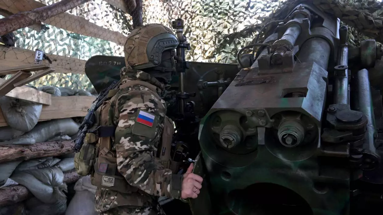 Un soldat rus pe front, stând camuflat lângă un lansator de rachete.
