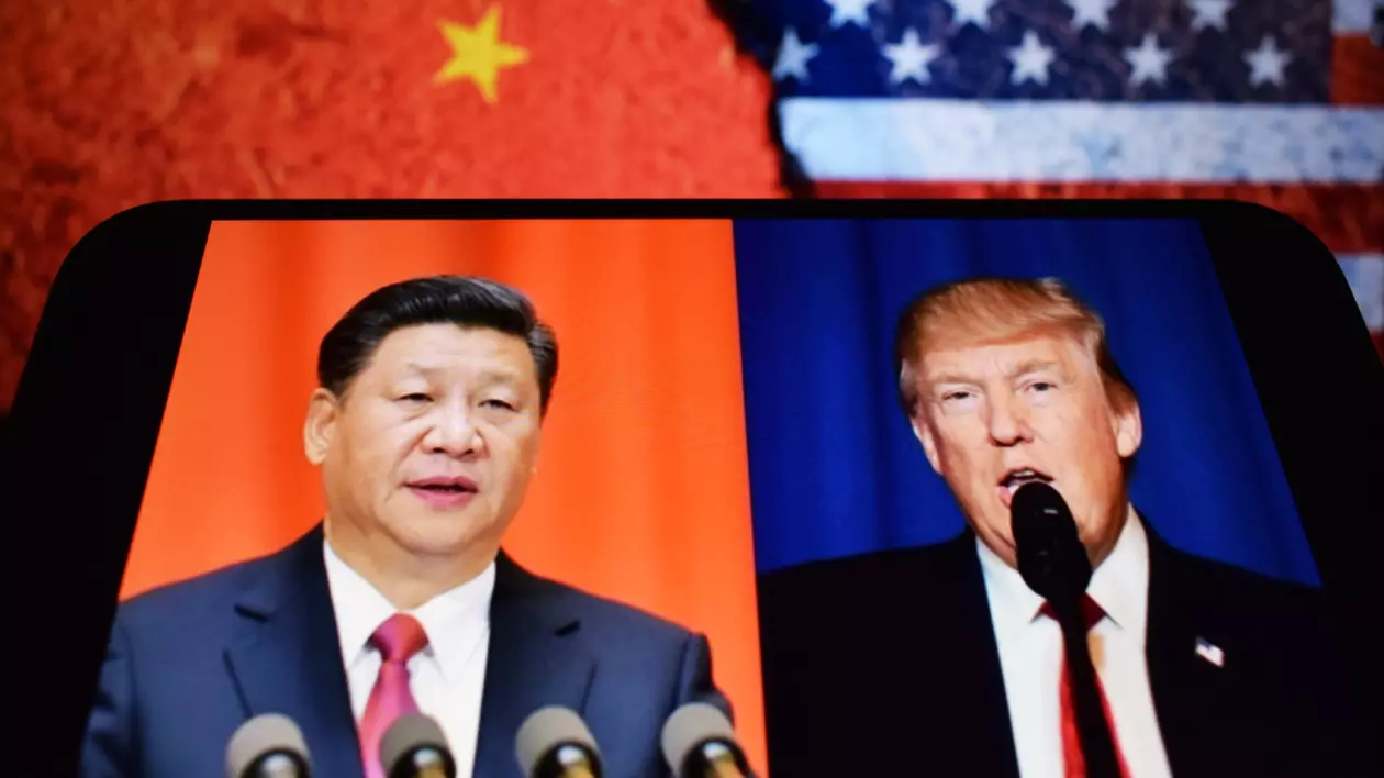 Pe fundal, steagul Chinei și steagul SUA. Iar pe ecranul unui telefon, în stânga, președintele Chinei, Xi Jinping, în dreapta, președintele SUA, Donald Trump. Amândoi sunt îmbrăcați la costum și vorbesc în timpul unei conferințe de presă.