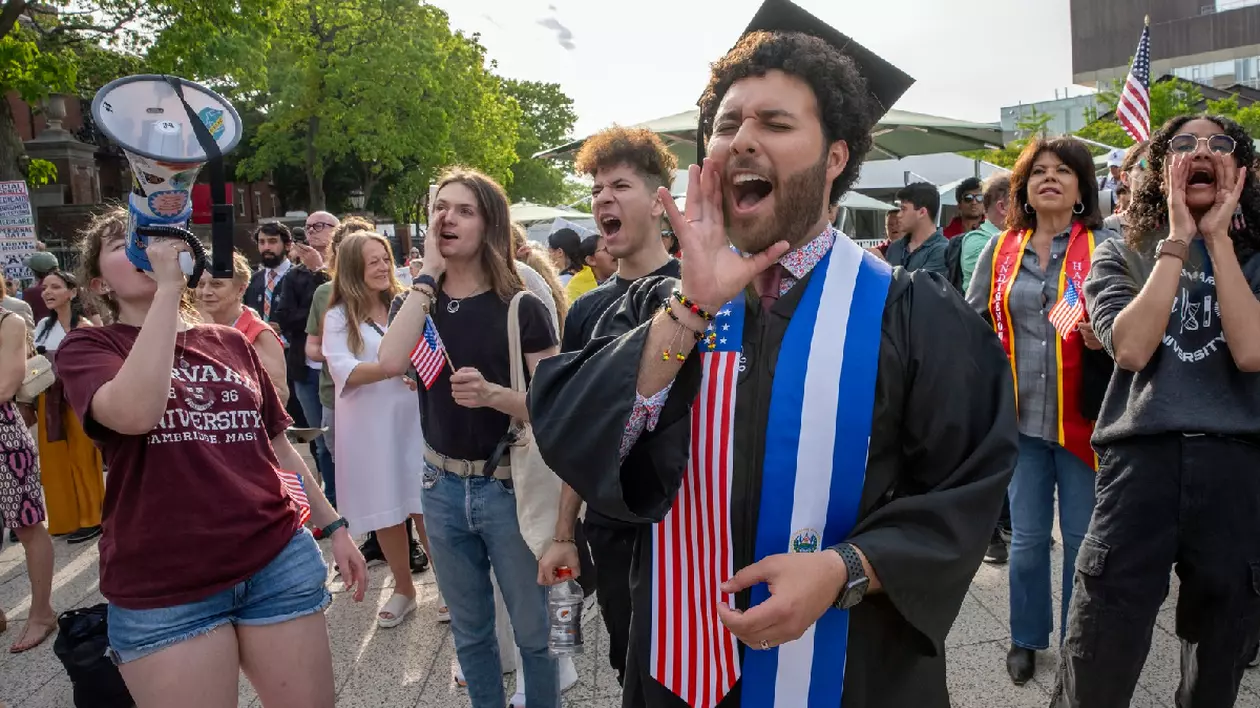 studenți Harvard în timp ce se bucură de absolvire, unul dintre ei, aflat în centrul imaginii surâde în timp ce strigă ceva