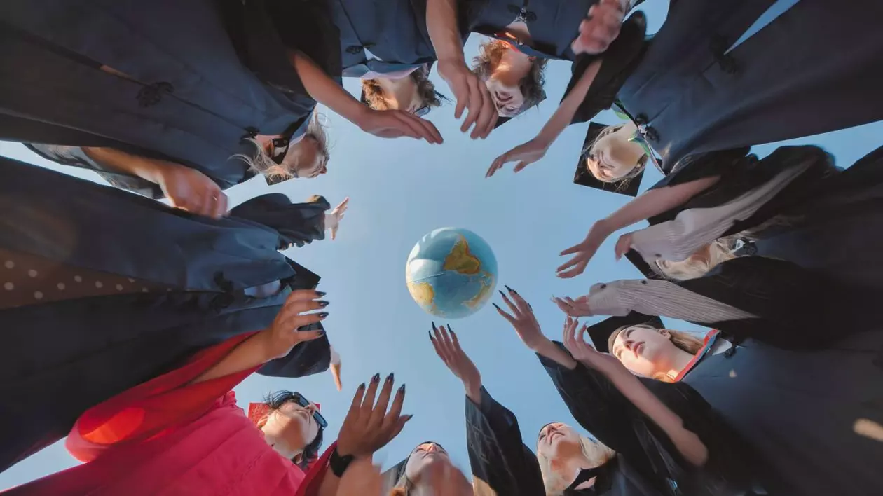 Grup de studenți la absolvire care aplaudă