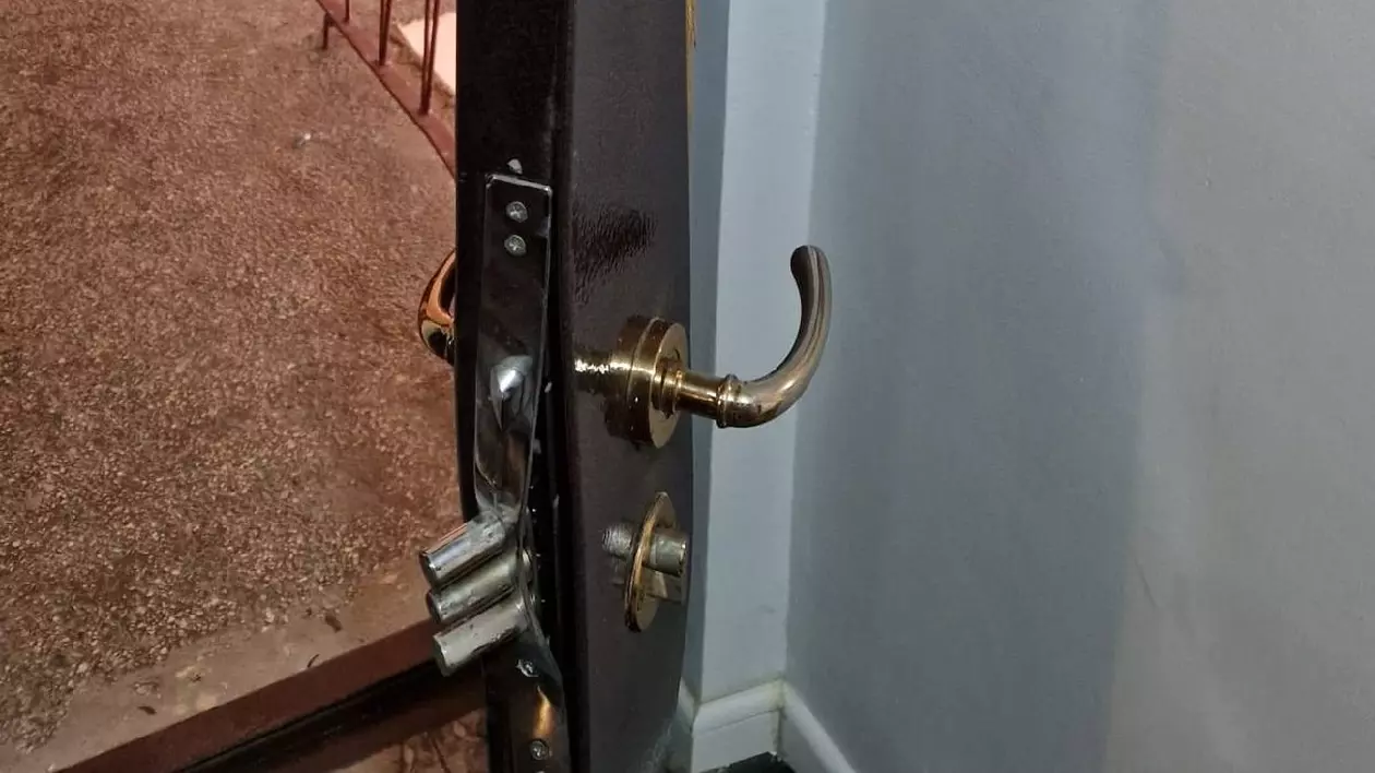 o ușă distrusă de mascați , broasca este ieșită prin materialul din care este făcută ușa