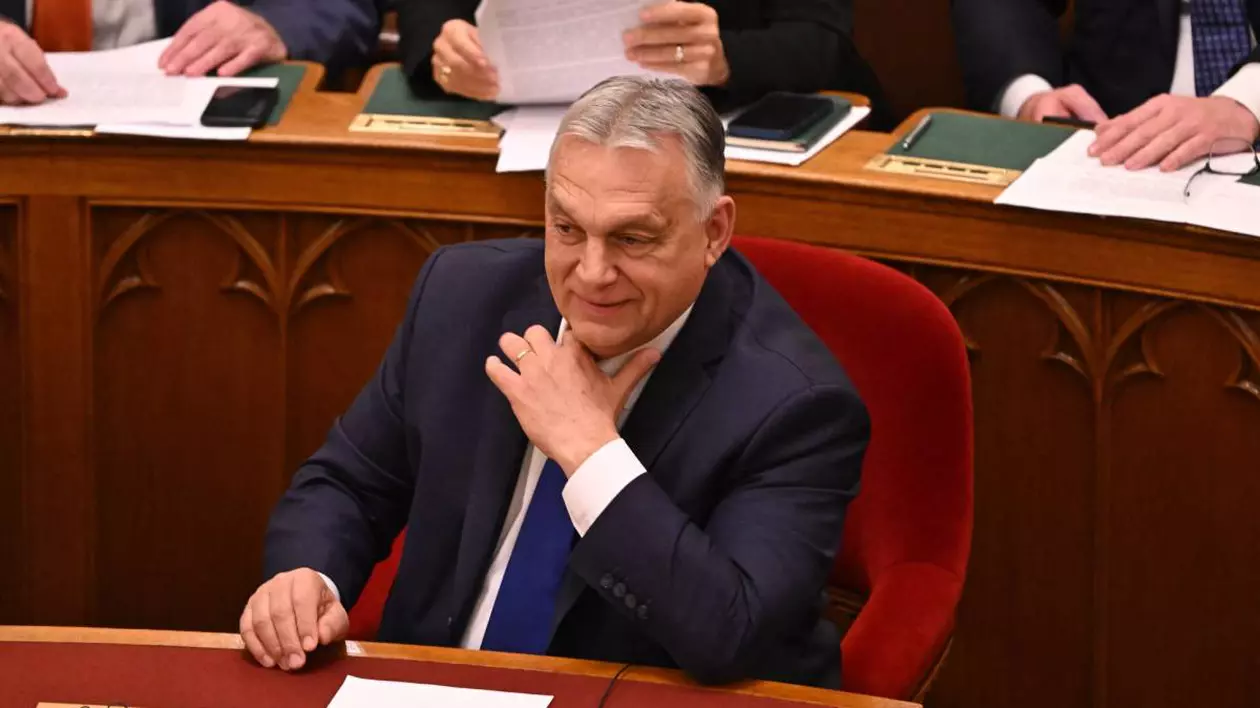 Premierul Viktor Orban, îmbrăcat la costum, cu o cravată albastră, în timp ce stă pe scaun în timpul unui discurs în Parlamentul Ungariei.