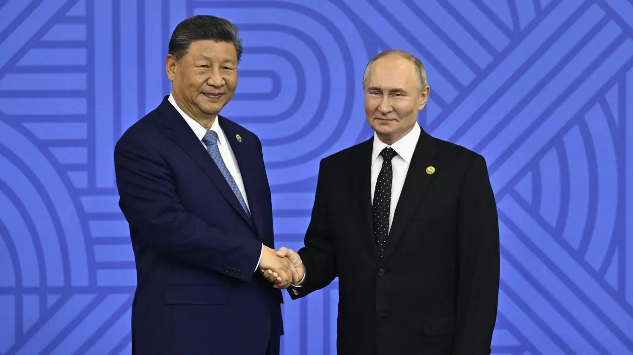 Xi Jinping (stânga) și Vladimir Putin (dreapta) își strâng mâinile în timpul unei ceremonii la summitul BRICS 2024 din Kazan - 23 octombrie 2024