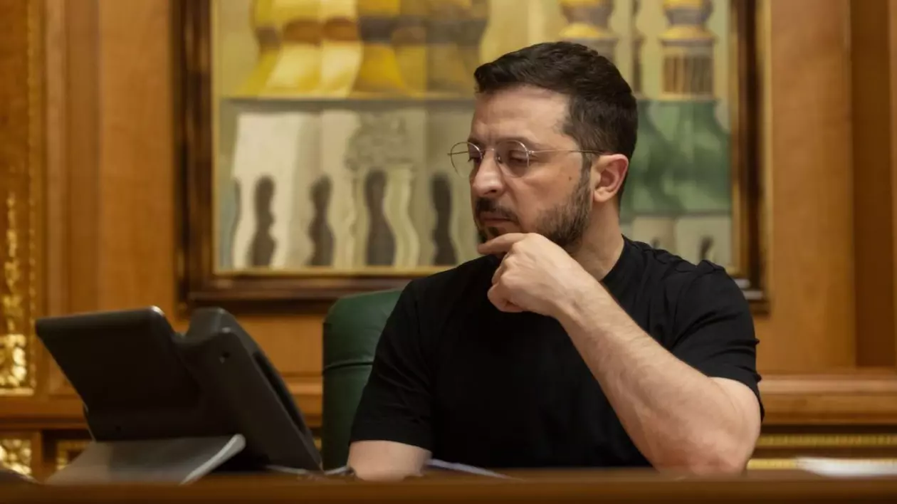 Președintele Ucrainei, Volodimir Zelensky, în biroul sau, analizand ceva pe laptop, cu ochelarii la ochi si imbracat cu un tricou negru