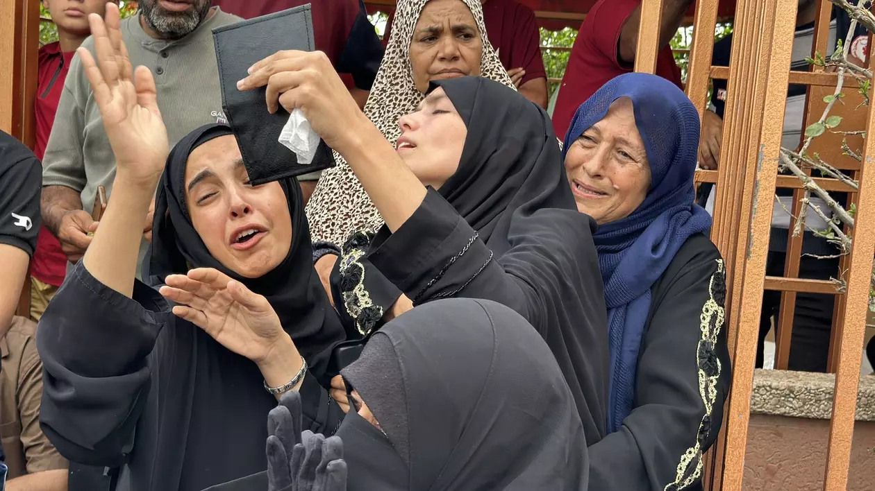 Patru femei surprinse în timp ce plâng pierderea celor dragi, în urma atacului lansat de armata israeliană asupra civililor care încercau să obțină mâncare