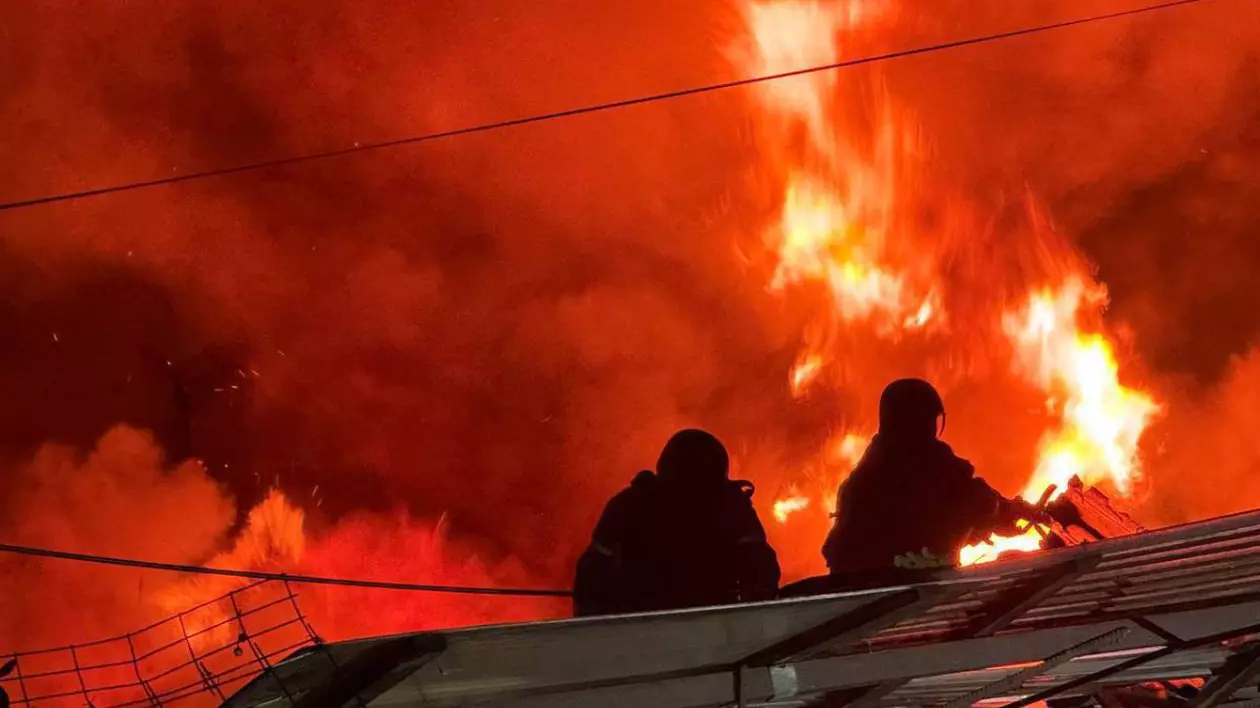 In imagine flacari puternice acopera totul, se vad siluetele a doi salvatori careincearca sa inetrvina