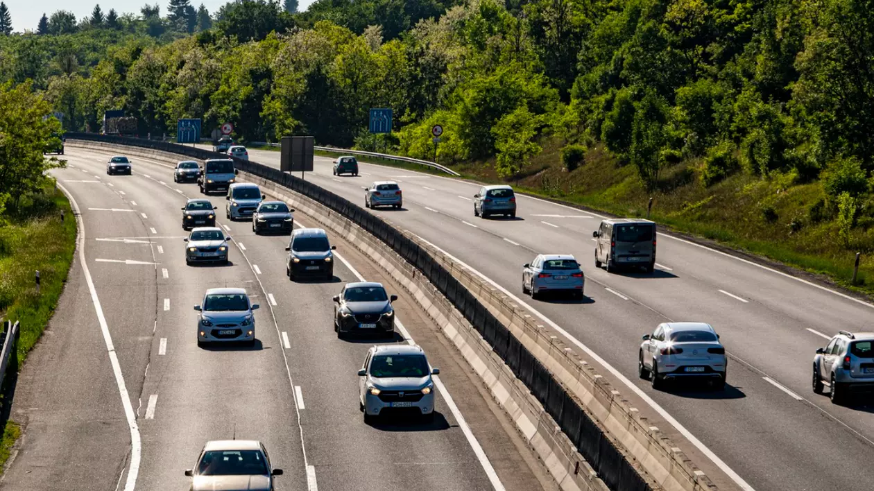 În imagine sunt ilustrate mașini care circulă pe o autostradă.