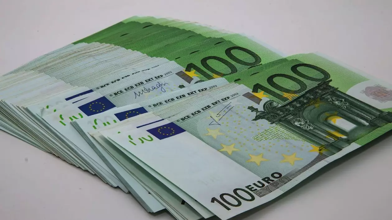 Imagine creativă cu bancnote de 100 de euro, pe o masă albă