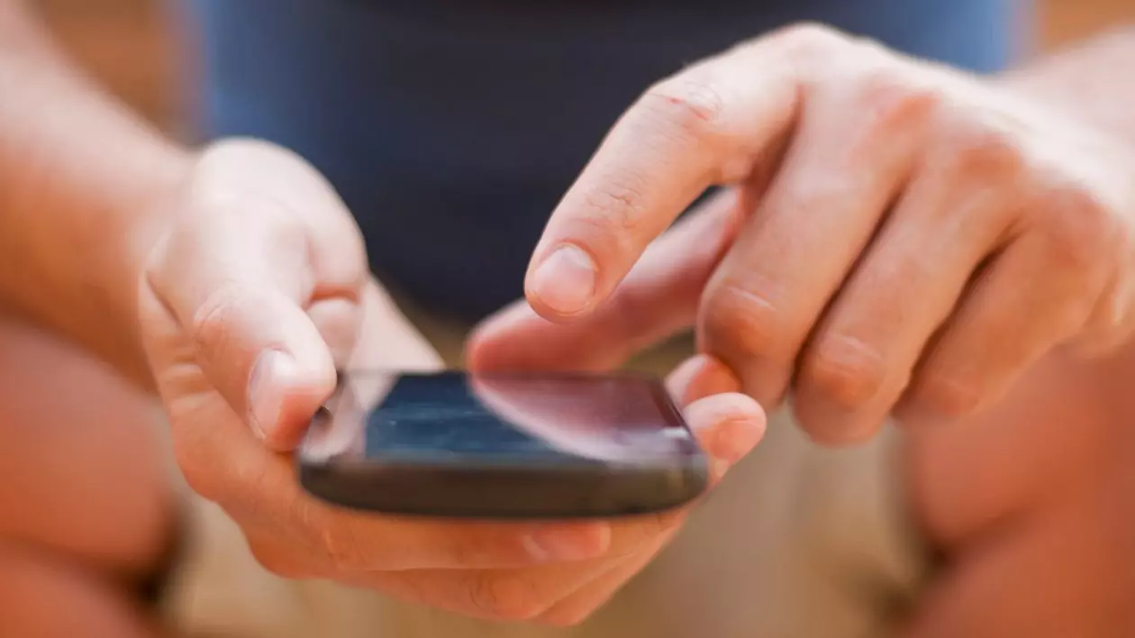 bărbat care scrie un mesaj pe telefonul mobil