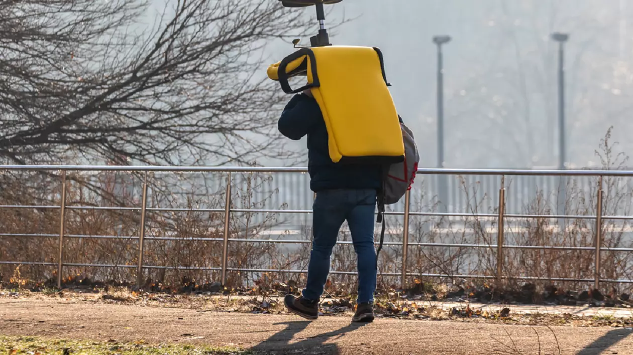 Ce înseamnă expresia „om cu scaun la cap” şi de unde vine - Imagine cu un bărbat care transportă un scaun de birou de culoare galbenă pe cap