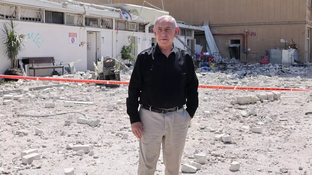 Benjamin Netanyahu surprins cu o mână în buzunar, în timpul vizitei la spitalul Soroka atacat de Iran, pe 19 iunie 2025. Premierul poartă o cămașă neagră și o pereche de pantaloni crem
