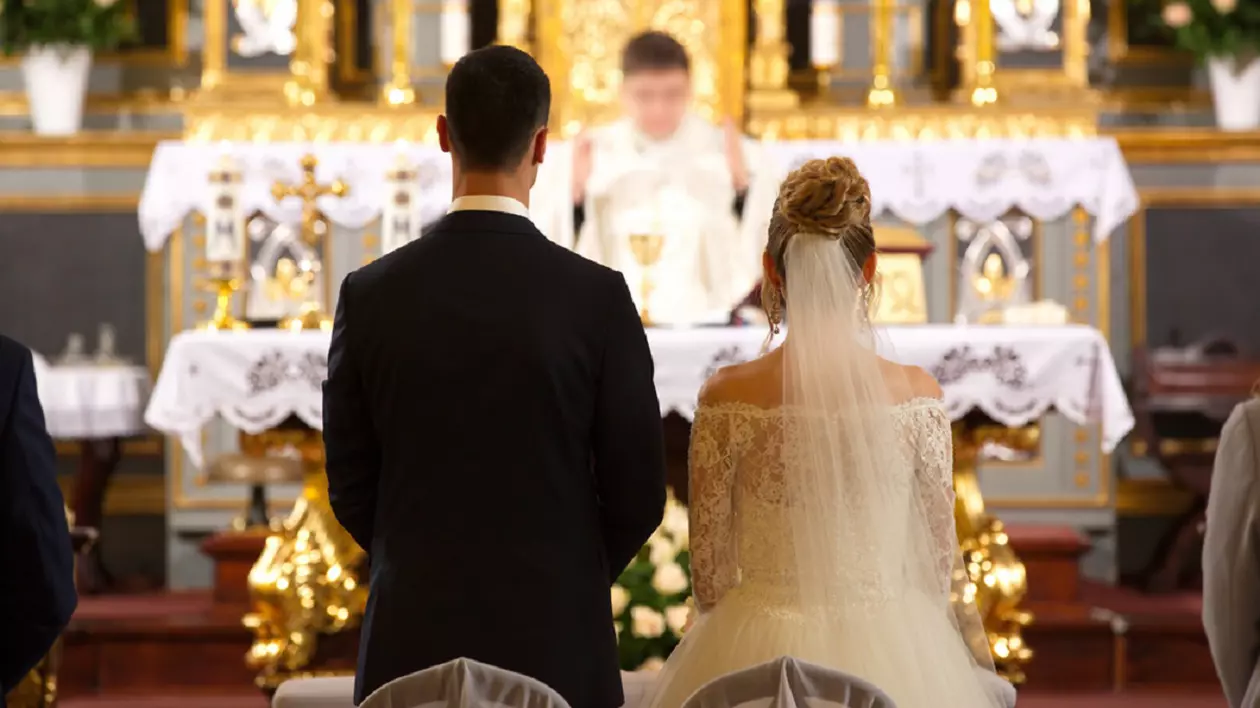 De ce este greşit să le urezi mirilor „casă de piatră” - Imagine cu doi miri aflaţi în faţa altarului, la cununia religioasă