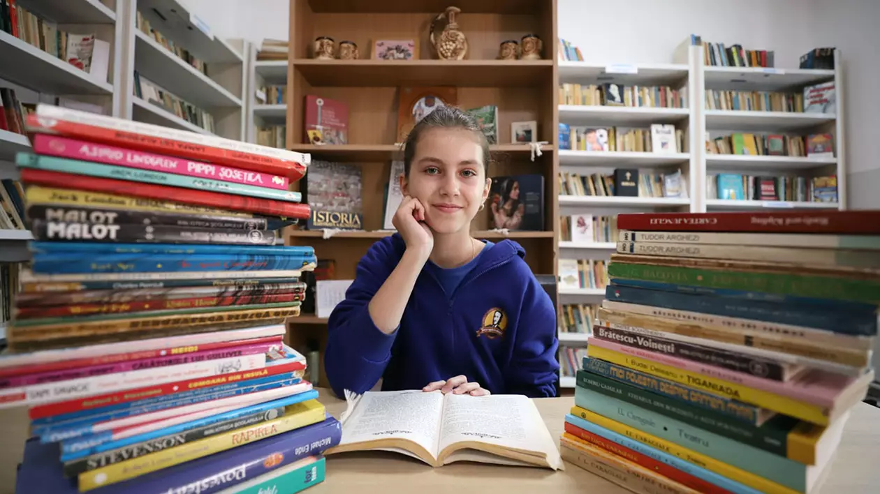 Cristiana Grecu stă la bibliotecă și citește o carte