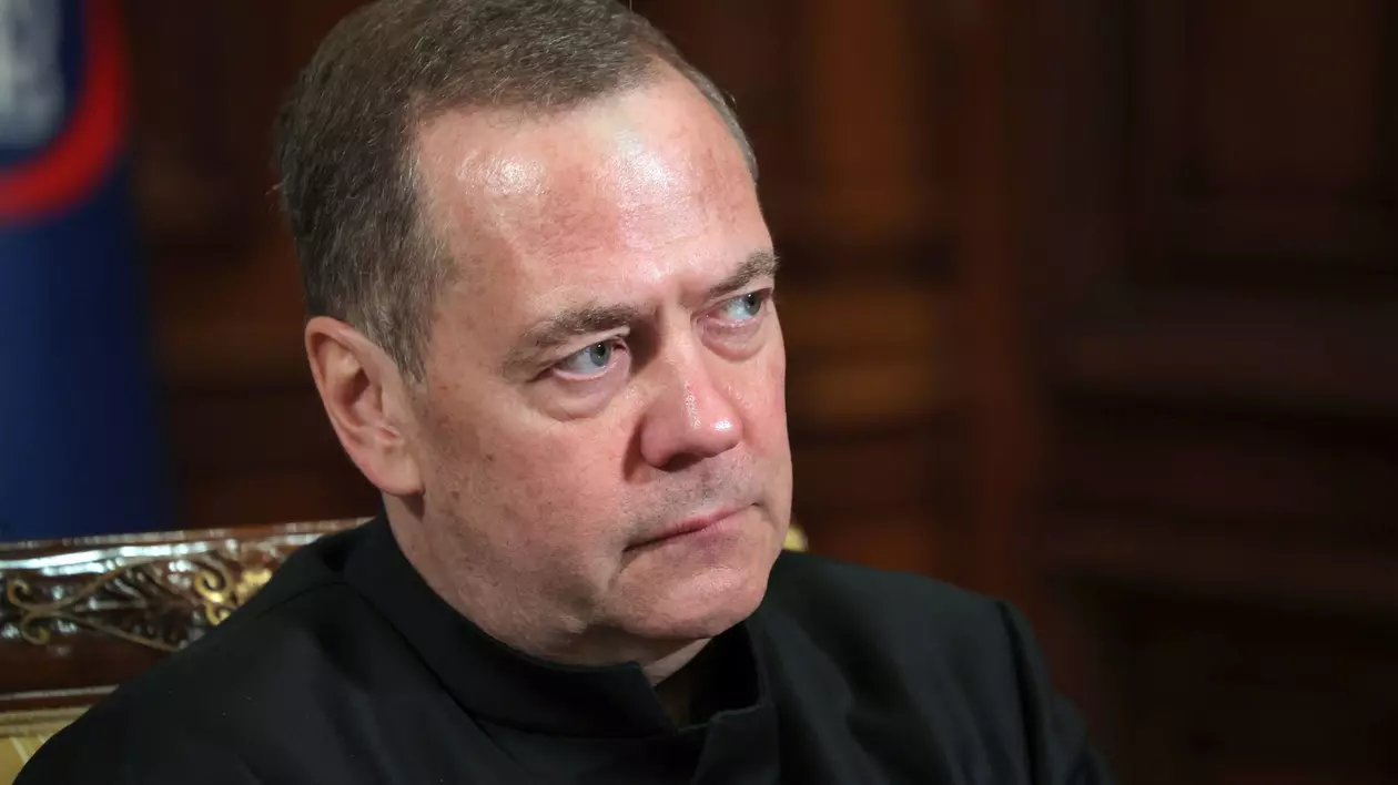 Imagine cu Dmitri Medvedev. Fostul președinte al Rusiei este surprins în timp ce se uită într-o parte. Este îmbrăcat în negru
