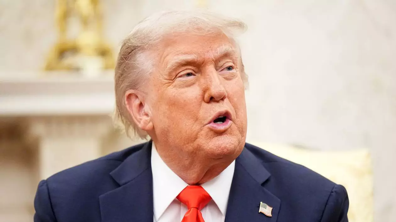 Președintele american Donald Trump în Biroul Oval, vorbește și are gura deschisă, poartă un costum albastru și o cravată roșie.