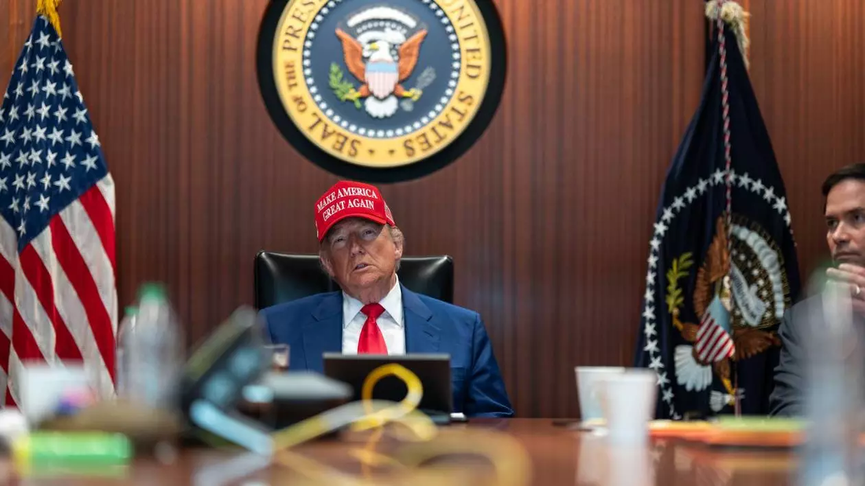 Donald Trump surprins în capul mesei, în Situation Room, stând serios și purtând o șapcă roșie cu sloganul „Make America Great Again”. Fotografia a fost realizată pe 21 iunie 2025