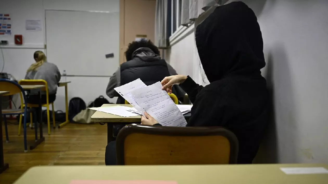 O elevă își verifică notițele înainte de începerea probei de filosofie din cadrul examenelor de bacalaureat la Liceul Edgar Quinet din Paris, la 18 iunie 2024.