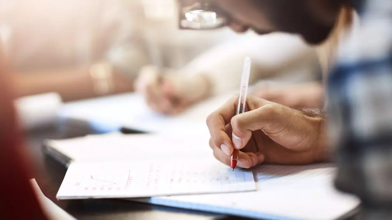 Elev scriind în timpul examenului