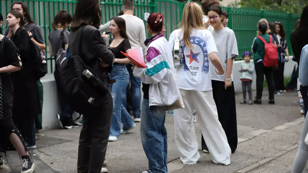 Un grup de elevi care discută despre subiectele la BAC 2025 stau pe trotuarul din fața Liceului Jean Monnet din București.
