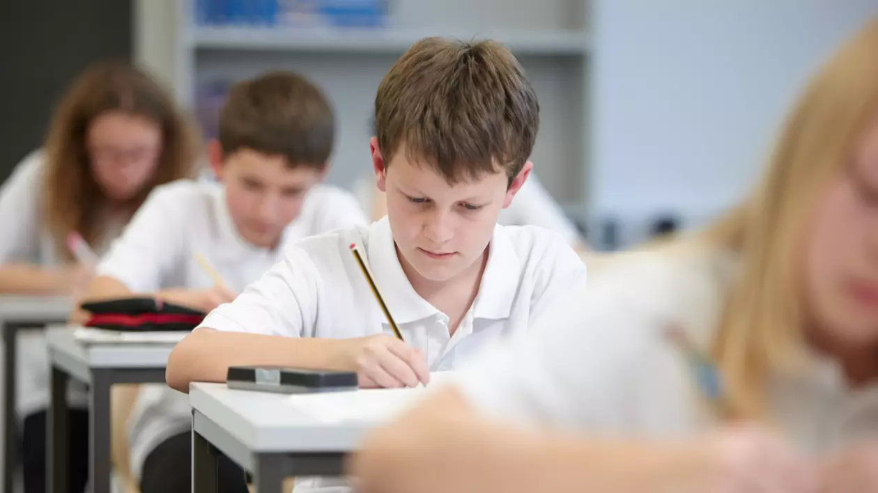 În imagine sunt ilustrați elevi care susțin un examen