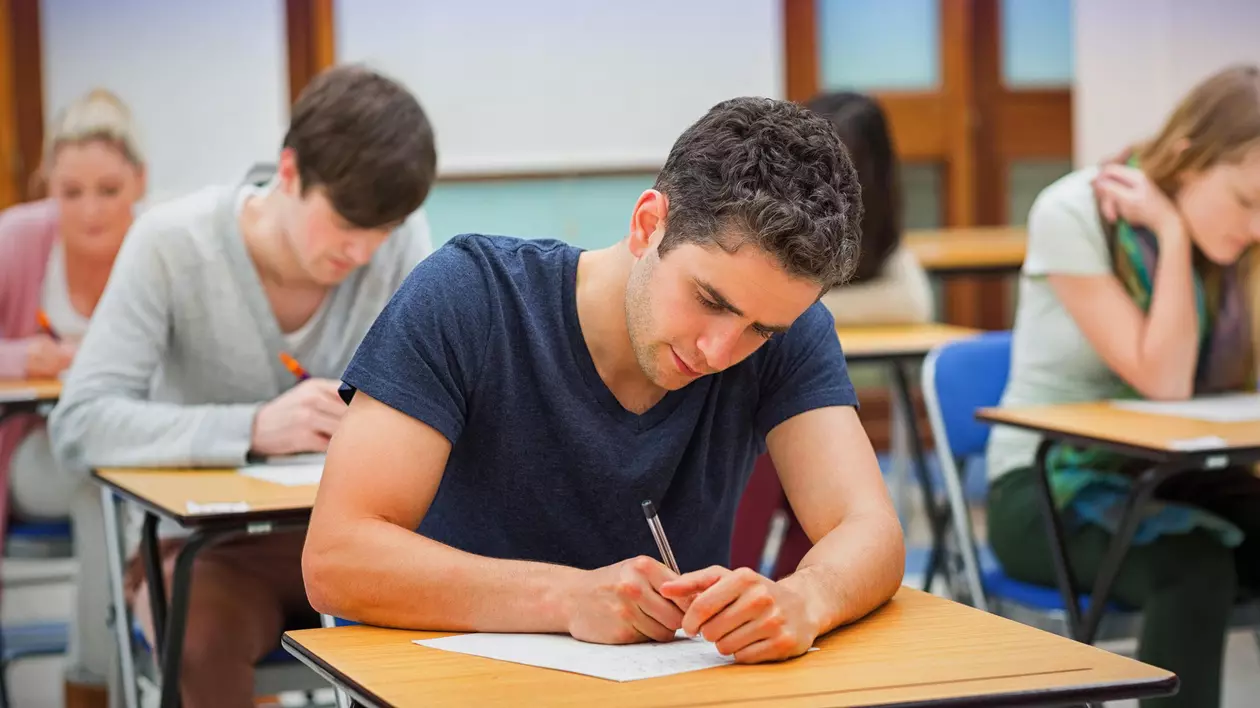 Studenți surprinși într-o sală de curs în timp ce susțin un examen