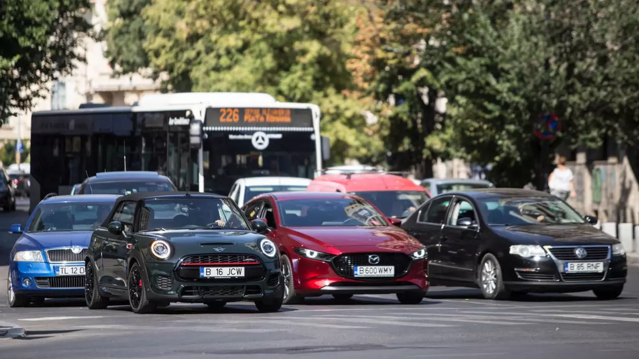 Mai julte mașini și un autobuz opresc în fața unei treceri de pietoni din București august 2020