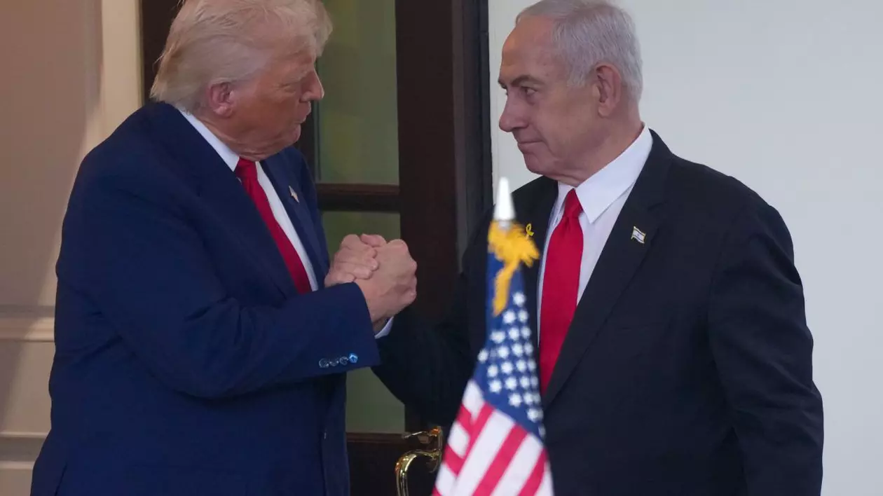Donald Trump dă mâna cu Benjamin Netanyahu stând în picioare și având în față un steag american, aprilie 2025