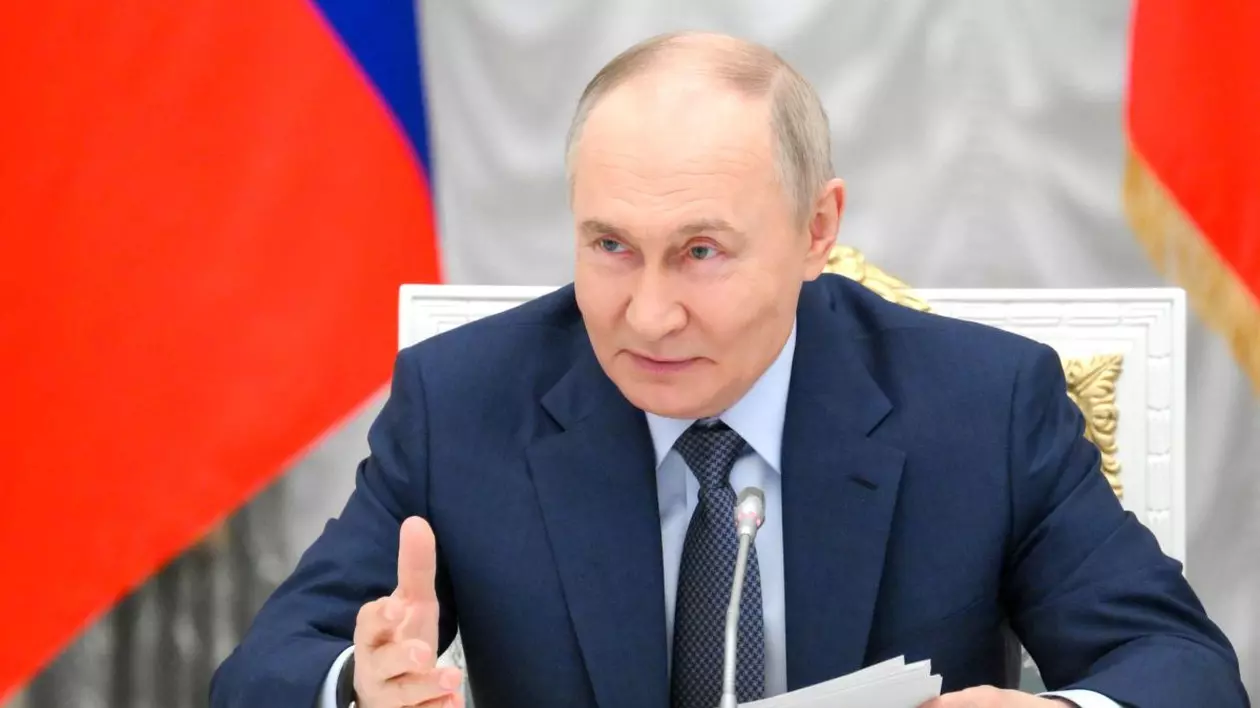 Președintele rus Vladimir Putin, îmbrăcat la costum și ținând în mână mai multe foi, vorbește în timpul unei conferințe la Kremlin, stând pe un scaun și având în spate steagul Federației Ruse Vladimir Putin - iunie 2025