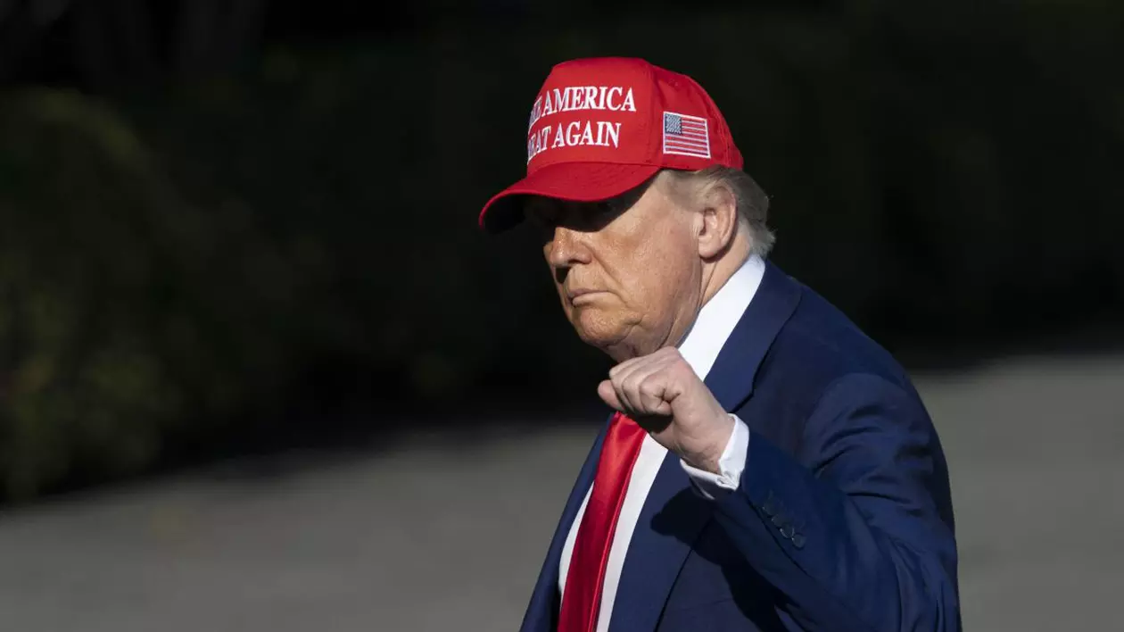 Președintele Statelor Unite, Donald Trump, se îndreaptă spre Casa Albă cu pumnul stâng strâns, în costum negru, având pe cap o șapcă roșie inscripționată cu sloganul „Make America Great Again”, iunie 2025